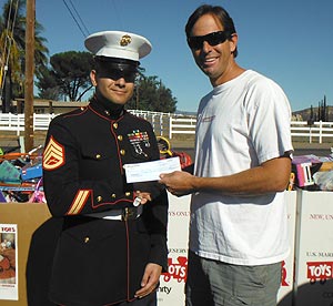 Staff Sergeant Colon accepts a check from WakeWorld's David Williams